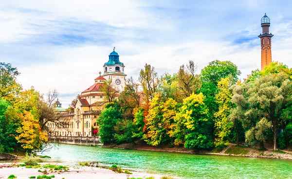 View on Colorful autumn landscape in front of Mueller Volksbad of Isar river - Munich shutterstock 1171899118